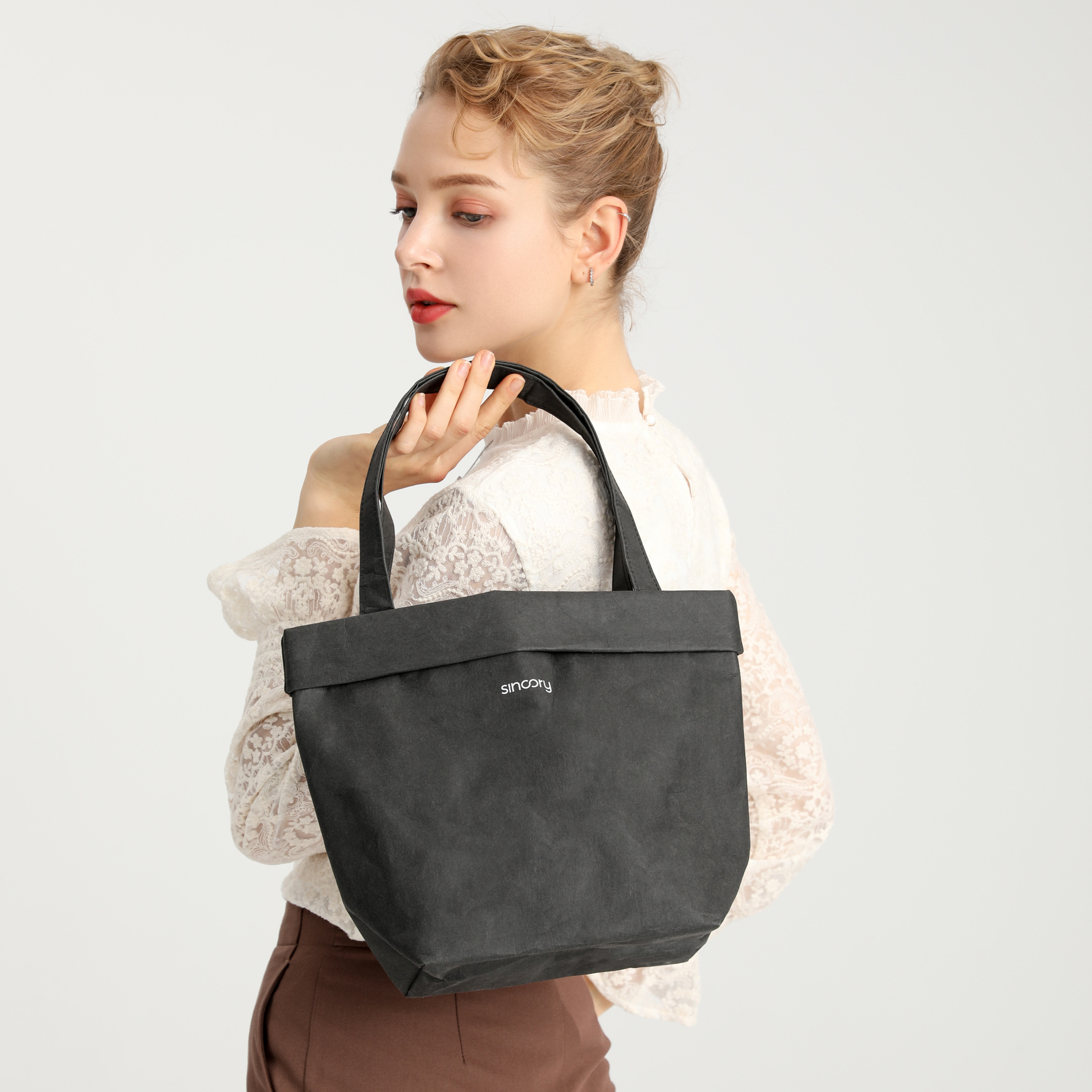 Model mit sincory black Henkeltasche ueber der Schulter